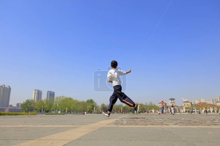 Téléchargez les photos : Une Chinoise pilotant un cerf-volant sur la place - en image libre de droit