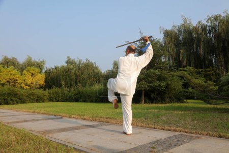 Foto de Condado de Luannan - 10 de agosto de 2017: Un artista marcial chino que practica la espada Taiji en un parque, Condado de Luannan, provincia de Hebei, China - Imagen libre de derechos