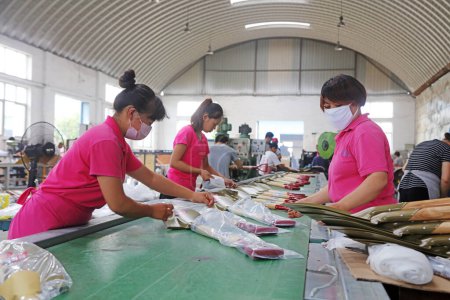 Téléchargez les photos : Comté de Luannan - 11 août 2017 : travailleuses occupées à emballer des pelles en acier dans une usine de fabrication à Luannan, Hebei, Chin - en image libre de droit