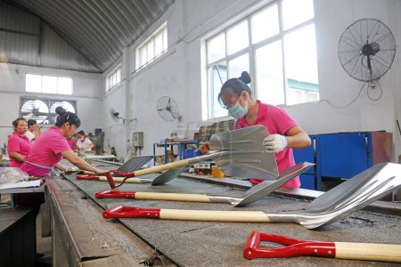 Téléchargez les photos : Comté de Luannan - 11 août 2017 : les travailleurs étaient occupés à assembler des pelles en acier dans une usine de fabrication à Luannan, Hebei, Chin - en image libre de droit