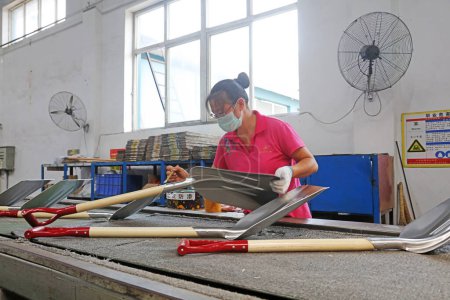 Téléchargez les photos : Comté de Luannan - 11 août 2017 : les travailleurs étaient occupés à assembler des pelles en acier dans une usine de fabrication à Luannan, Hebei, Chin - en image libre de droit