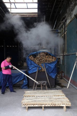 Téléchargez les photos : Comté de Luannan - 11 août 2017 : travailleurs de la chaîne de production de fumigation du bois dans une usine de fabrication de bêches en acier, comté de Luannan, province du Hebei, Chin - en image libre de droit