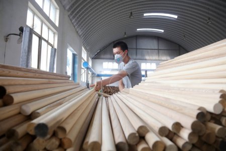 Téléchargez les photos : Comté de Luannan - 11 août 2017 : travailleurs dans la chaîne de production de la poignée en bois, dans une usine de fabrication de pelles en acier, Luannan, Hebei, Chin - en image libre de droit