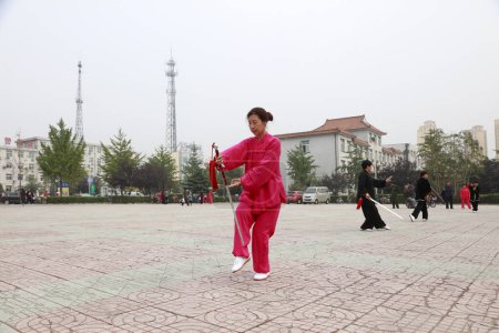 Téléchargez les photos : LUANNAN COUNTY, China - October 15, 2017: Taiji Sword performance in the square, LUANNAN COUNTY, Hebei Province, China - en image libre de droit