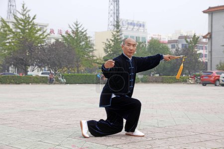 Foto de LUANNAN COUNTY, China - October 15, 2017: Taiji Sword performance in the square, LUANNAN COUNTY, Hebei Province, China - Imagen libre de derechos