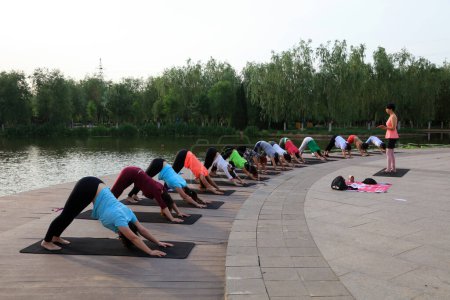 Foto de Condado de Luannan - 10 de junio de 2017: Varias mujeres haciendo ejercicio de yoga en el parque, condado de luannan, provincia de hebei, China - Imagen libre de derechos