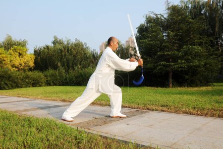 Téléchargez les photos : Comté de Luannan - 10 août 2017 : Un artiste martial chinois pratiquant l'épée Taiji dans un parc, comté de Luannan, province du Hebei, Chine - en image libre de droit