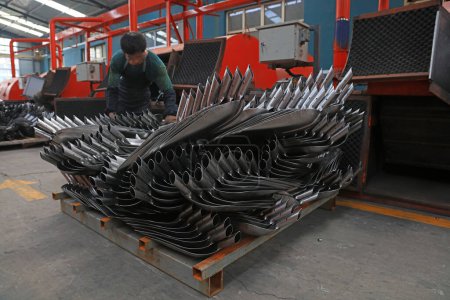 Foto de Condado de Luannan, China - 22 de agosto de 2017: Los trabajadores están ocupados en la línea de producción de palas de acero en una fábrica, Condado de Luannan, provincia de Hebei, China - Imagen libre de derechos