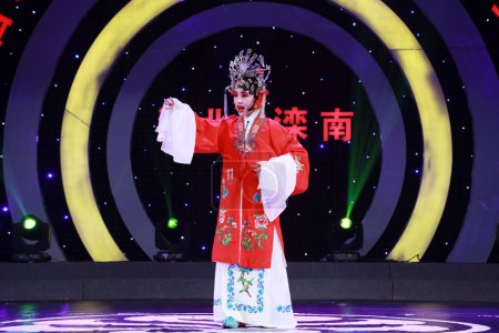 Foto de LUANNAN COUNTY, China - 7 de septiembre de 2017: una chica vestida con traje clásico chino interpreta la Ópera de Pekín en el escenario del condado de LUANNAN, provincia de Hebei, China - Imagen libre de derechos