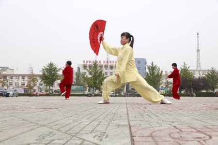 Photo for LUANNAN COUNTY, China - October 15, 2017: Tai Chi Kung Fu Fan Performance in the square, LUANNAN COUNTY, Hebei Province, China - Royalty Free Image