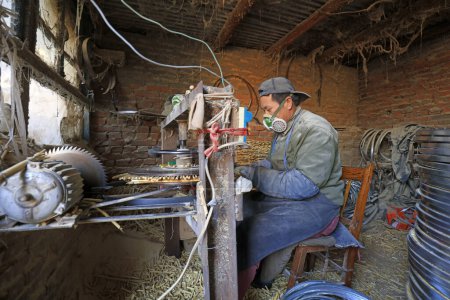 Photo for Luannan County - December 21, 2017: workers processing cover curtains in a handmade workshop, Luannan County, Hebei Province, China. This is the most important traditional handicraft industry in the local area - Royalty Free Image