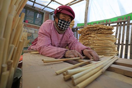 Photo for Luannan County - December 21, 2017: workers processing cover curtains in a handmade workshop, Luannan County, Hebei Province, China. This is the most important traditional handicraft industry in the local area - Royalty Free Image