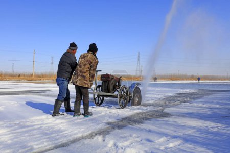Téléchargez les photos : Comté de Luannan - 23 janvier 2018 : les agriculteurs coupent la glace dans le champ avec des machines à découper, Luannan, Hebei, Chin - en image libre de droit