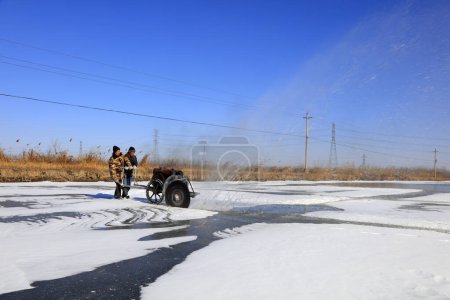 Téléchargez les photos : Comté de Luannan - 23 janvier 2018 : les agriculteurs coupent la glace dans le champ avec des machines à découper, Luannan, Hebei, Chin - en image libre de droit