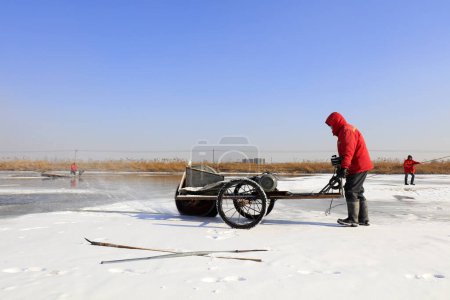 Photo for Luannan County - January 26, 2018: farmers cut ice in the field with cutting machines, Luannan, Hebei, Chin - Royalty Free Image