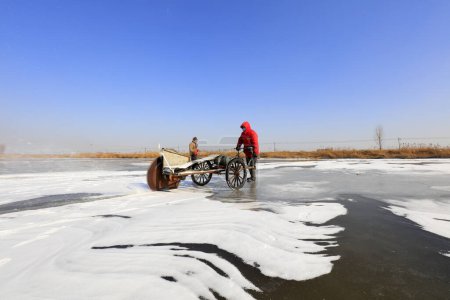 Téléchargez les photos : Luannan County - January 26, 2018: farmers cut ice in the field with cutting machines, Luannan, Hebei, Chin - en image libre de droit