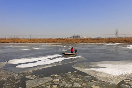 Photo for Luannan County - January 26, 2018: farmers use small boats to drive ice in the wild, Luannan, Hebei, Chin - Royalty Free Image