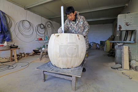 Téléchargez les photos : Luannan County - February 6, 2018: drum craftsman is measuring the height of the drum in workshops, Luannan, Hebei, Chin - en image libre de droit