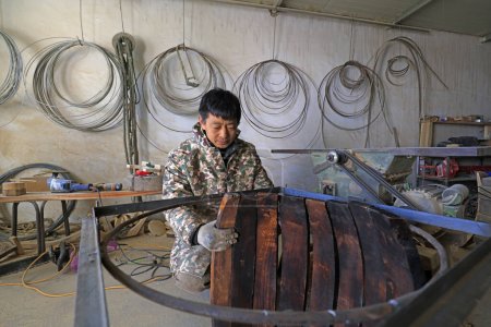 Téléchargez les photos : Luannan County - February 6, 2018: craftsman is working on the side board of the wooden drum in workshops, Luannan, Hebei, Chin - en image libre de droit