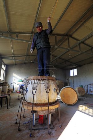 Foto de Luannan County - February 6, 2018: craftsman is treading drumhead in workshops, Luannan, Hebei, Chin - Imagen libre de derechos