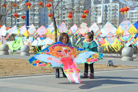 Photo for Luannan county - February 22, 2018: a mother and daughter watched a kite, luannan county, hebei province, China - Royalty Free Image