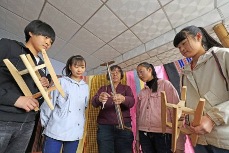 Foto de Condado de Luannan - 30 de marzo de 2018: varios estudiantes de secundaria durante una visita al proceso de tejido indígena en el condado de Luannan, provincia de Hebei, Chines - Imagen libre de derechos