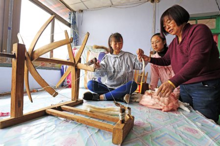 Foto de Condado de Luannan, 30 de marzo de 2018: Tecnología de tejido indígena que hereda a las personas, guiando a los estudiantes a usar trabajadores de hilado, Condado de Luannan, provincia de Hebei, China - Imagen libre de derechos
