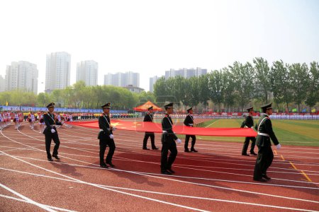 Foto de Tangshan City - 26 de abril de 2018: guardia de la bandera en la reunión deportiva de la escuela intermedia, Tangshan City, Hebei, China - Imagen libre de derechos