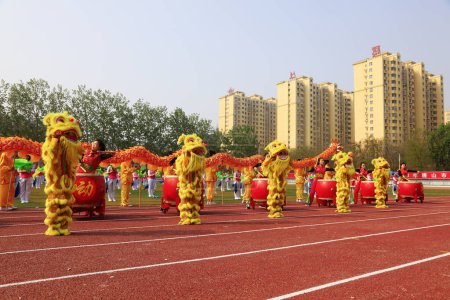 Foto de Tangshan City - 26 de abril de 2018: gran grupo de actuaciones gimnásticas en la reunión deportiva de la escuela intermedia, Tangshan City, Hebei, Chin - Imagen libre de derechos