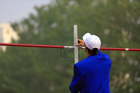 Photo for High jump field staff are adjusting the height - Royalty Free Image