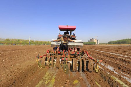 Téléchargez les photos : COMTÉ DE LUANNAN, Chine - 27 avril 2018 : les agriculteurs utilisent des machines agricoles pour planter des arachides à film plastique sur une ferme, COMTÉ DE LUANNAN, province du Hebei, Chine - en image libre de droit