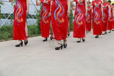 Photo for Red cheongsam ladies in the park - Royalty Free Image