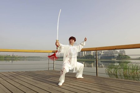 Téléchargez les photos : COMTÉ DE LUANNAN, Chine - 27 mai 2018 : Une femme pratique l'épée de Tai Chi dans le parc, COMTÉ DE LUANNAN, province du Hebei, Chin - en image libre de droit