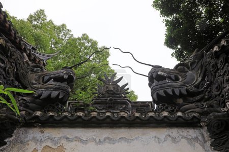 Téléchargez les photos : Shanghai, Chine - 31 mai 2018 : La sculpture de la tête du dragon est sur le mur dans le jardin Yu, Shanghai, Chine - en image libre de droit