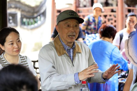 Téléchargez les photos : Shanghai, Chine - 2 juin 2018 : Un instructeur âgé explique aux touristes au jardin Yu, Shanghai, Chine - en image libre de droit