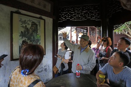 Téléchargez les photos : Shanghai, Chine - 2 juin 2018 : Un instructeur âgé explique aux touristes au jardin Yu, Shanghai, Chine - en image libre de droit