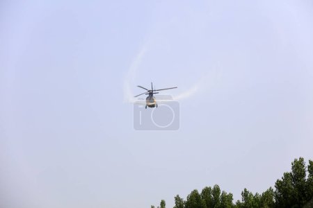 Téléchargez les photos : Hélicoptères Pulvérisation de pesticides dans l'air - en image libre de droit