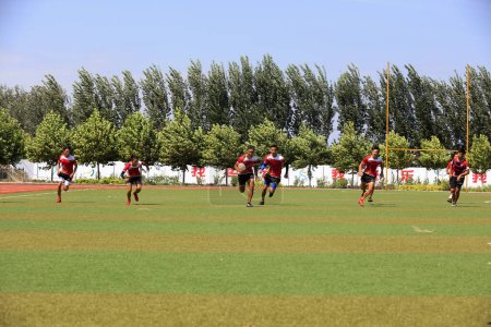Foto de Condado de Luannan - 16 de agosto de 2018: entrenamiento de rugby en un patio de recreo en una escuela intermedia, Condado de Luannan, provincia de Hebei, China - Imagen libre de derechos