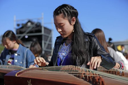 Photo for Tangshan City, China - October 7, 2018: Guzheng playing performance in the park, Hebei Province, China - Royalty Free Image