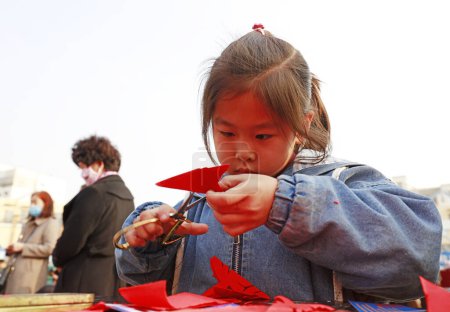 Photo for Luannan County - October 14, 2018: A little girl learning Chinese traditional paper-cut art, Luannan County, Hebei Province, Chin - Royalty Free Image