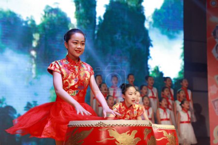 Foto de LUANNAN COUNTY, China - 19 de abril de 2019: Las niñas están tocando la batería en el escenario, LUANNAN COUNTY, Hebei Province, China - Imagen libre de derechos