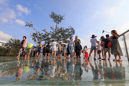 Photo for Sanya City, China - April 1, 2019: tourists play on the sea view glass trestle, Sanya City, Hainan Province, China - Royalty Free Image