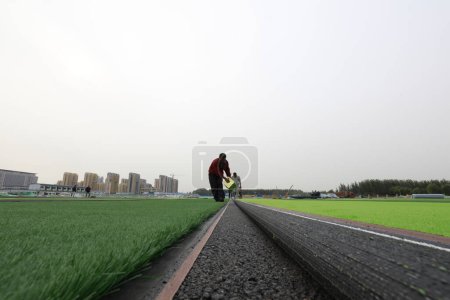 Photo for LUANNAN COUNTY - Oct. 15, 2018: Artificial lawn laying site in a sports field, Luannan County, Hebei Province, China - Royalty Free Image