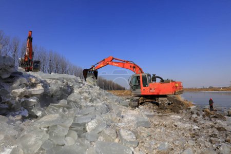 Photo for Luannan County - January 26, 2018: Excavator collate ice in the field, Luannan County, Hebei Province, Chin - Royalty Free Image