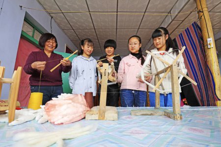 Photo for Luannan County, March 30, 2018: Indigenous weaving technology inheriting people, guiding students to use spinning workers, Luannan County, Hebei Province, China - Royalty Free Image