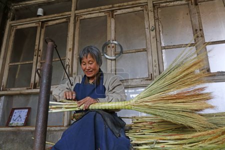 Photo for Luannan County - April 24, 2018: worker processing the broom in the workshop, Luannan County, Hebei Province, China - Royalty Free Image