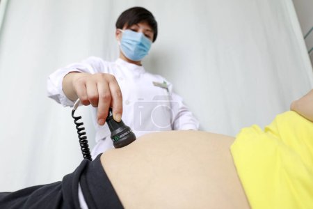Foto de Condado de Luannan - 11 de mayo de 2018: Enfermera realiza monitoreo cardíaco fetal para mujeres embarazadas, Condado de Luannan, Hebei, China - Imagen libre de derechos