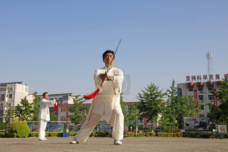 Téléchargez les photos : Comté de Luannan - 19 mai 2018 : performance de l "épée Taiji chinoise sur la place, comté de Luannan, province du Hebei, Chine - en image libre de droit
