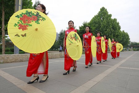 Foto de CONDADO DE LUANNAN, China - 9 de junio de 2018: Mujeres en cheongsam actúan en el parque, condado de LUANNAN, provincia de Hebei, China - Imagen libre de derechos