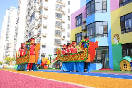 Téléchargez les photos : COMTÉ DE LUANNAN, Chine - 14 juin 2018 : Les enfants de la maternelle jouent à des jeux de bateau dragon, COMTÉ DE LUANNAN, province du Hebei, Chine - en image libre de droit